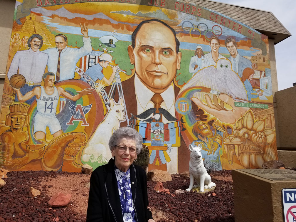 Carrasco's mother in front of mural of his father.